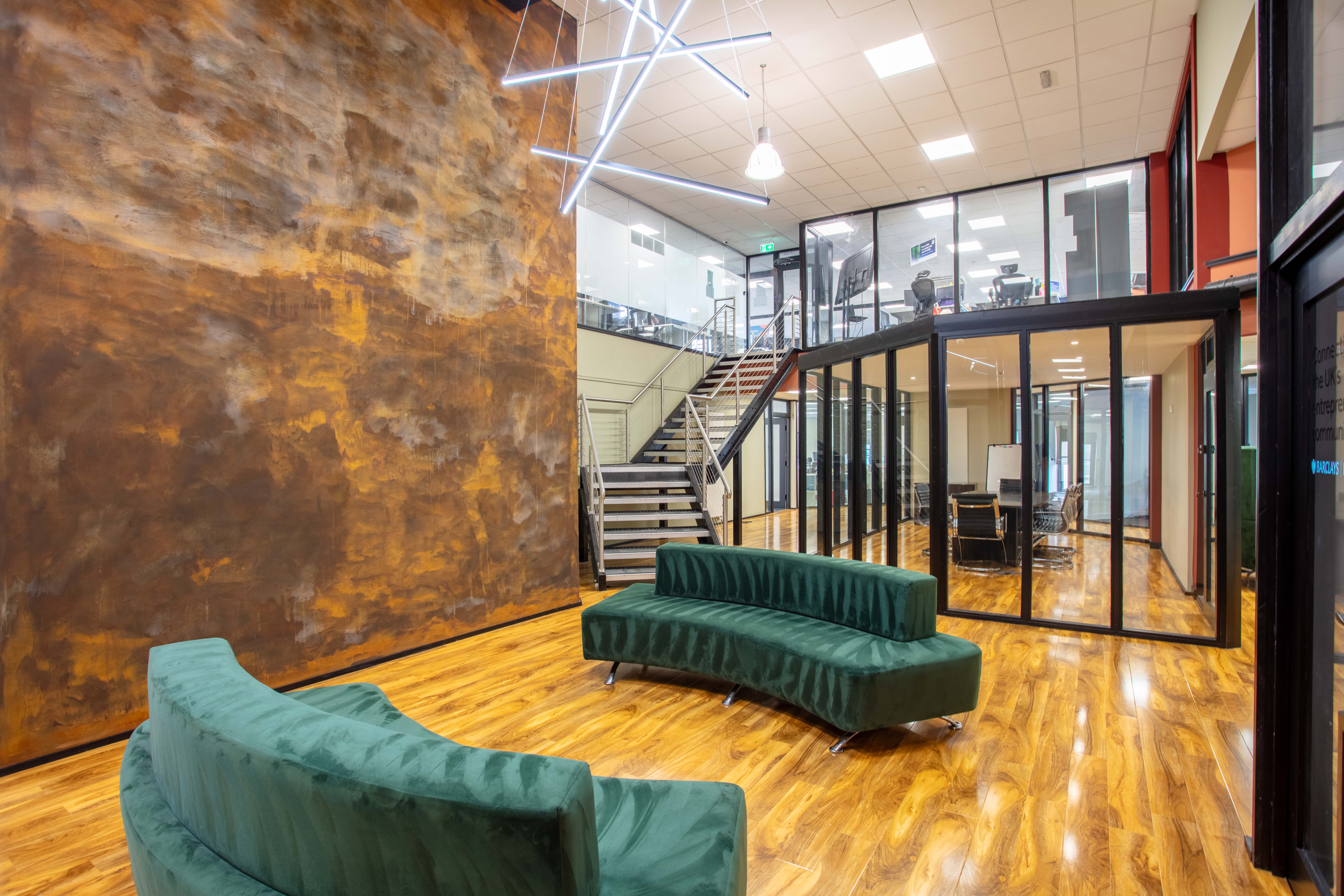 A modern, open-plan coworking breakout space in Corespace Kilmarnock with large windows and contemporary furniture
