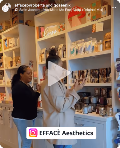 Two women browsing skincare and beauty products on white shelves in a store with warm lighting.