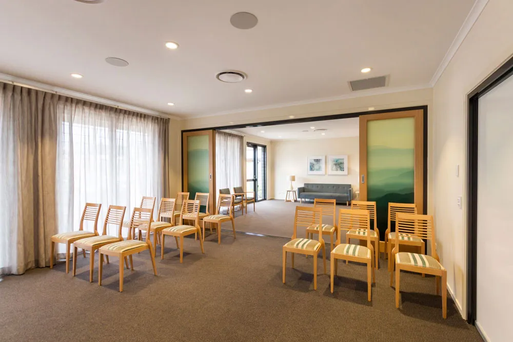 Room with tables and chairs, ready for a gathering.