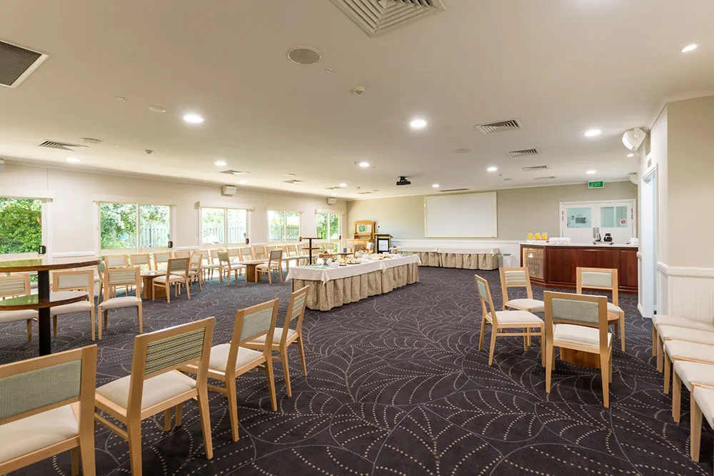 Long function room with many tables and chairs.