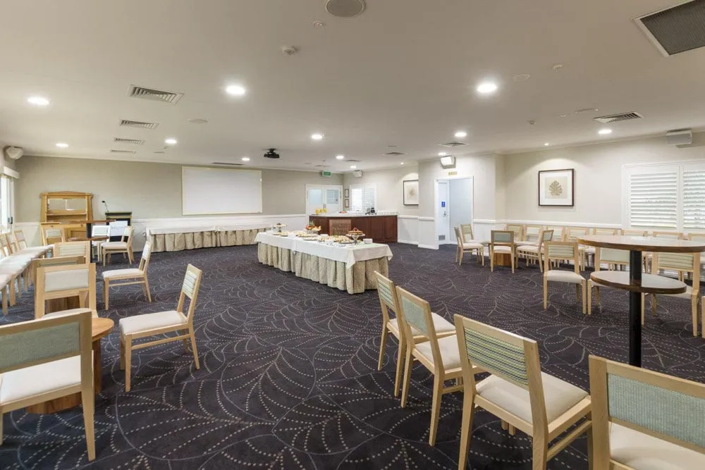 Spacious function room with tables and chairs set up.