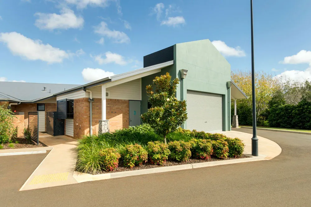 Modern building exterior with garage door and landscaping.