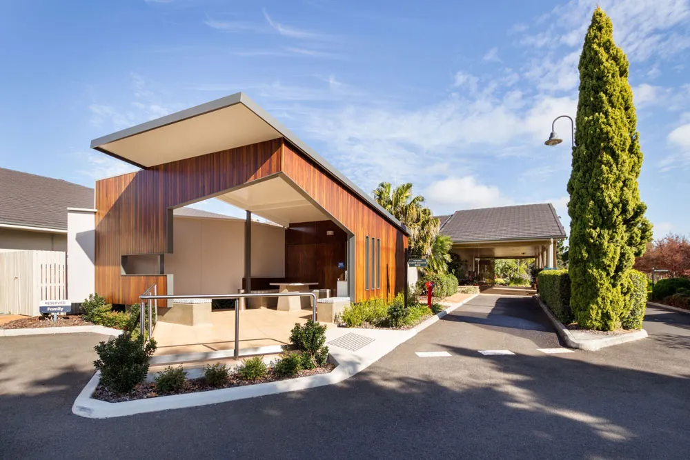 Modern outdoor shelter with wooden facade and seating.