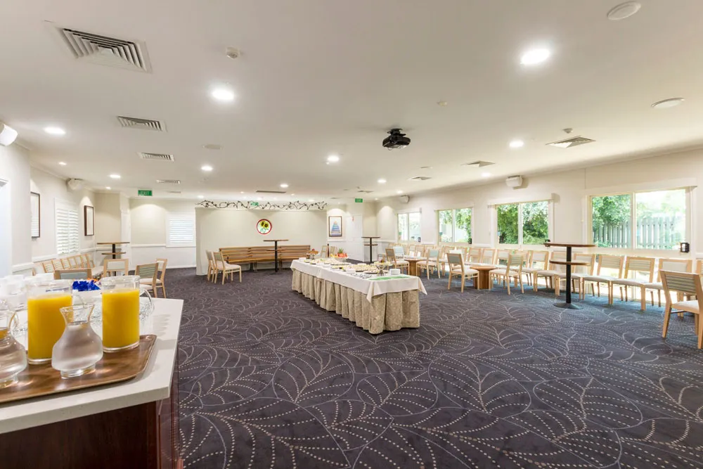Large function room with buffet, tables, and juice bar.