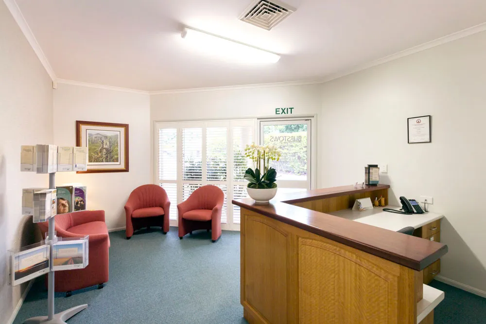 Reception area with desk, seating, and lighting..