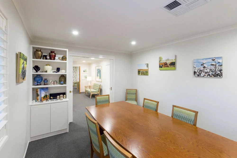 Spacious dining room with long table and built-in shelves.
