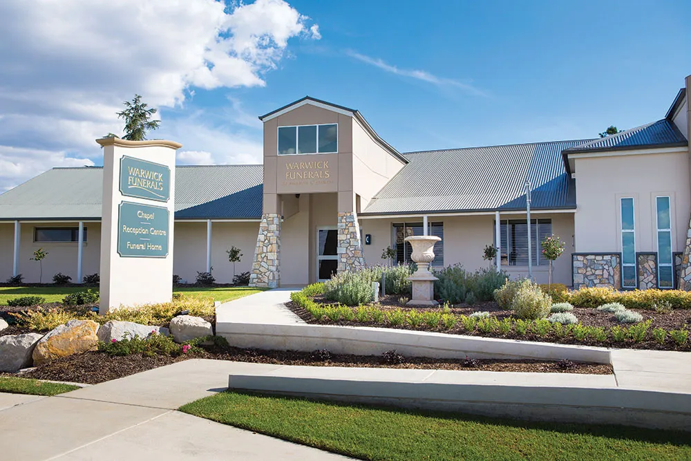 Modern building exterior with blue sky and landscaping.