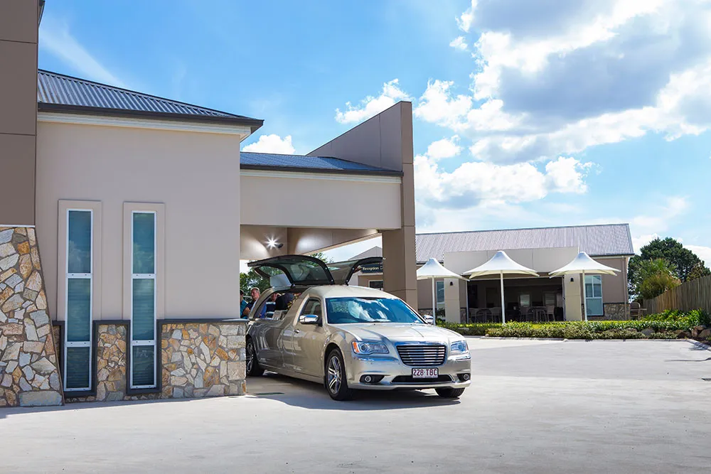 Modern building exterior with a silver car parked.