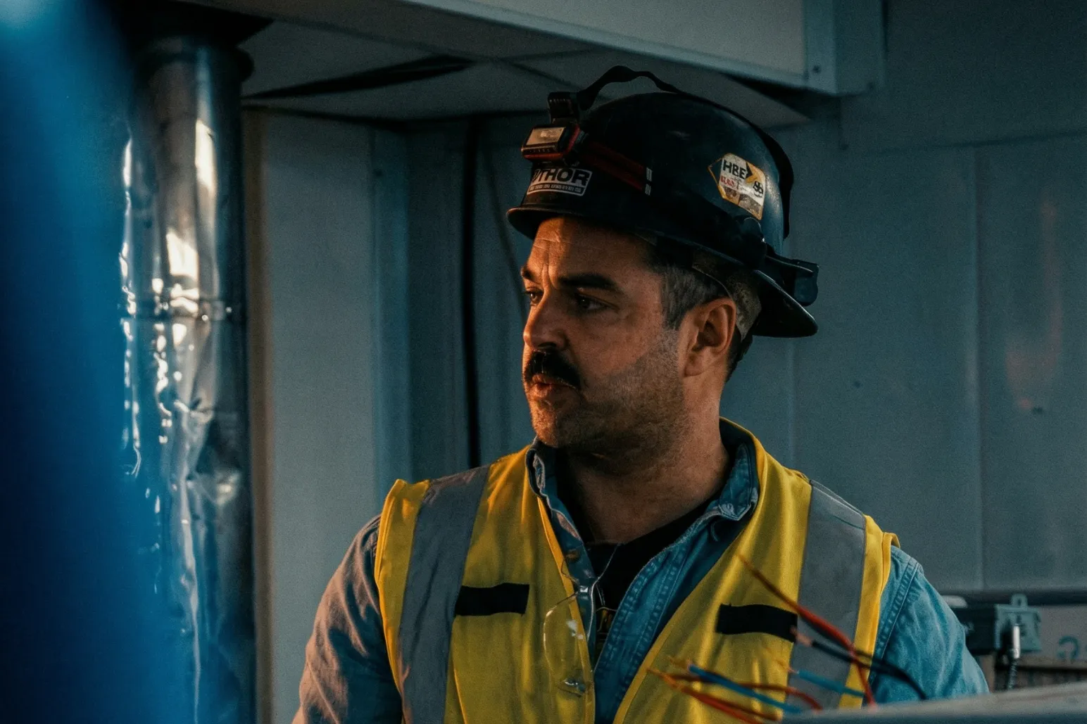 Construction worker in yellow safety vest on indoor commercial project
