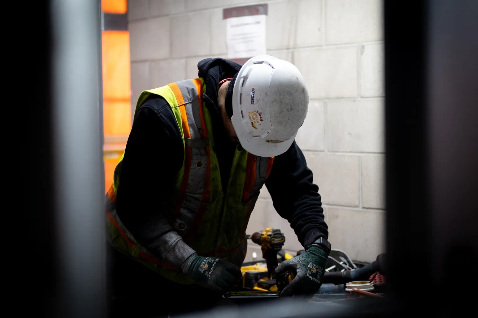 onstruction worker using power drill on indoor commercial project