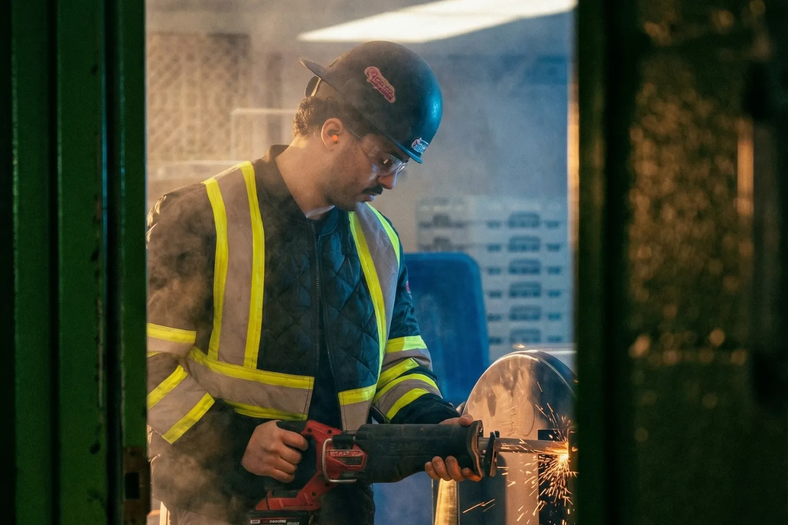 Construction worker using angle grinder with sparks flying on metal cutting