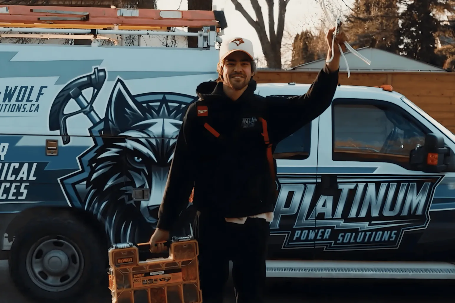 University of Manitoba Bisons team captain holding bicycle frame overhead in garage