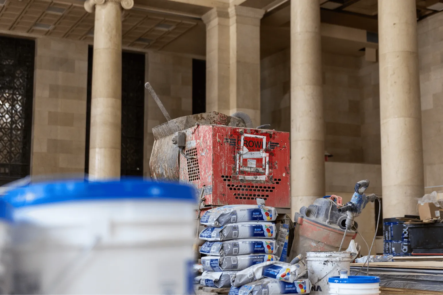 Construction site interior with equipment materials and limestone columns