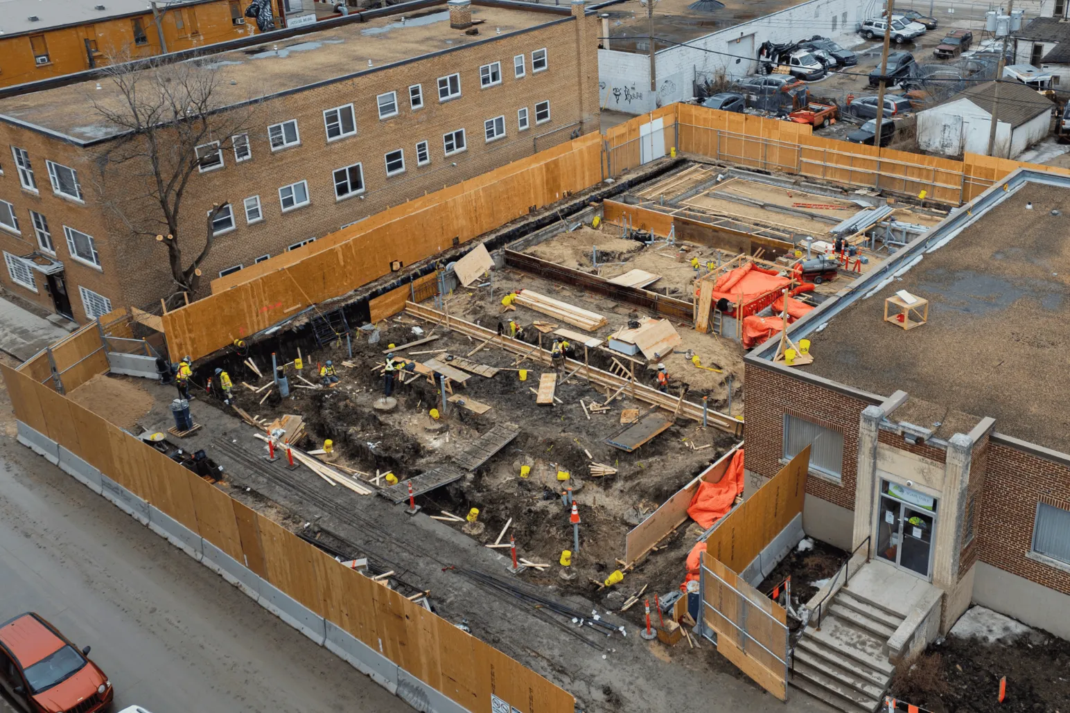Aerial drone view of commercial construction site courtyard with workers and materials