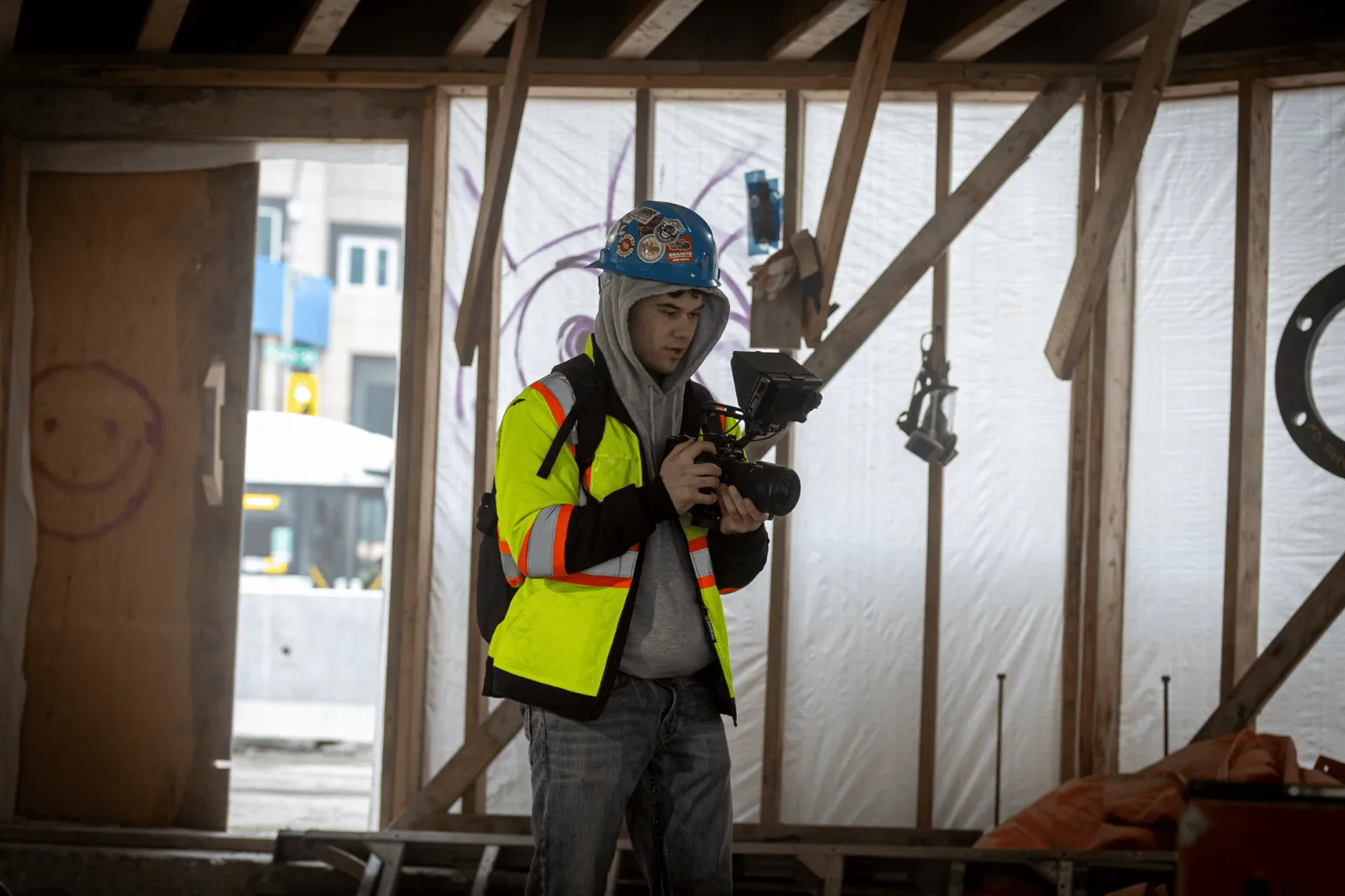 Videographer with camera filming Portage and Main construction project downtown Winnipeg