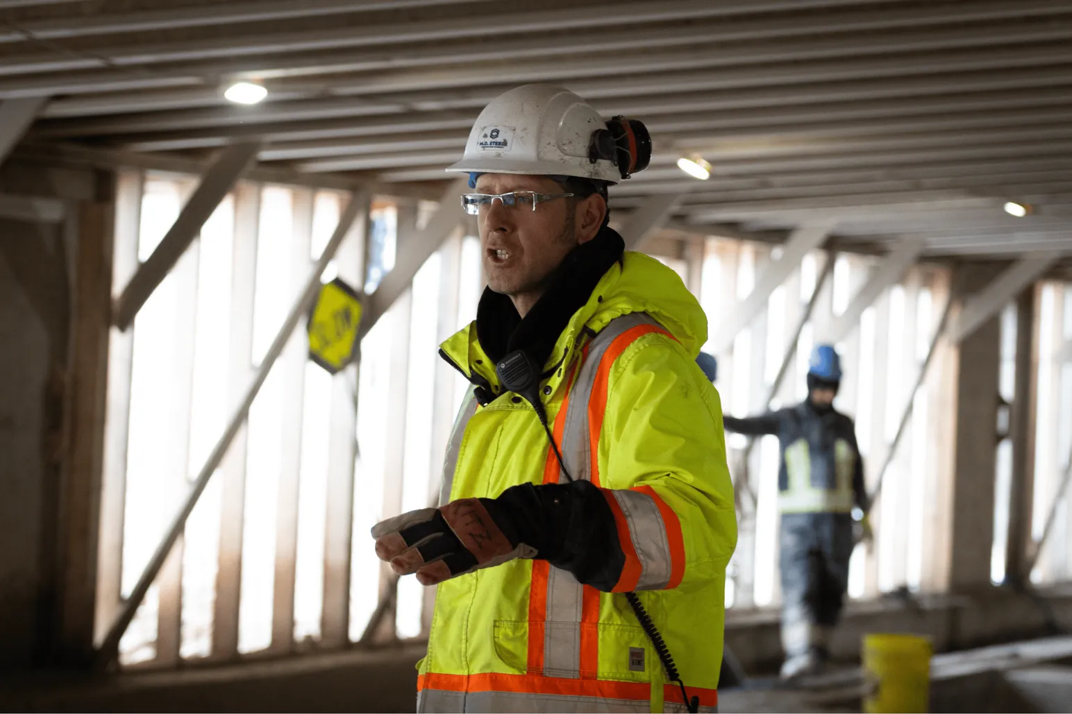 Construction supervisor with radio communicating in underground tunnel workspace