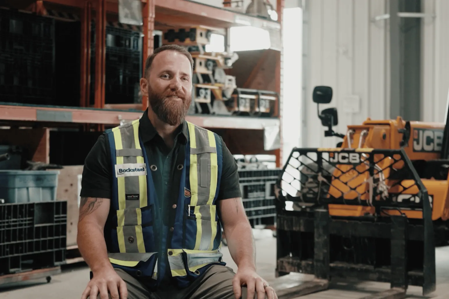 Bockstael Construction superintendent interview filming with JCB equipment background