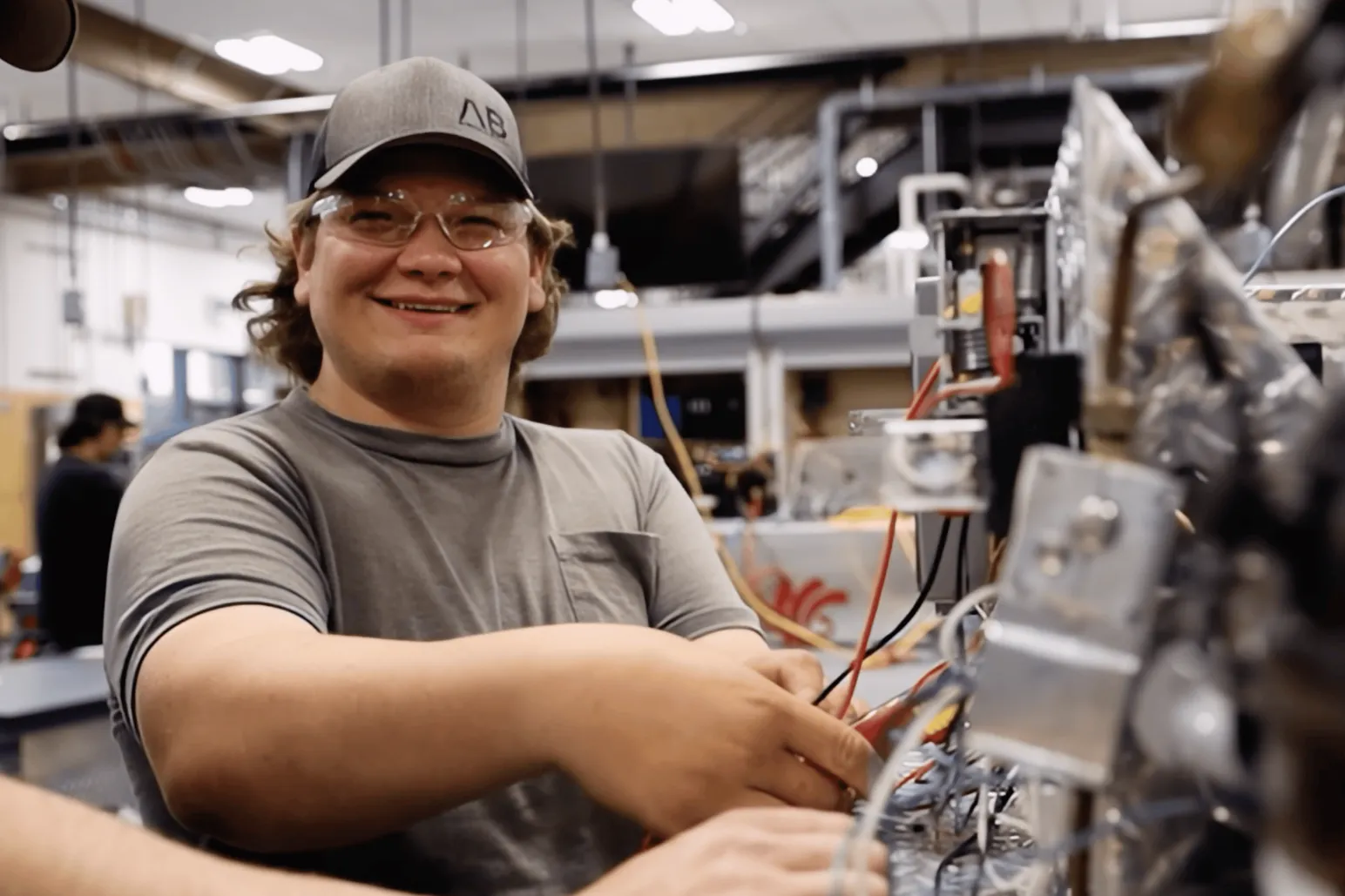 Electrical trades student working on technical wiring project at RRC Polytech training facility