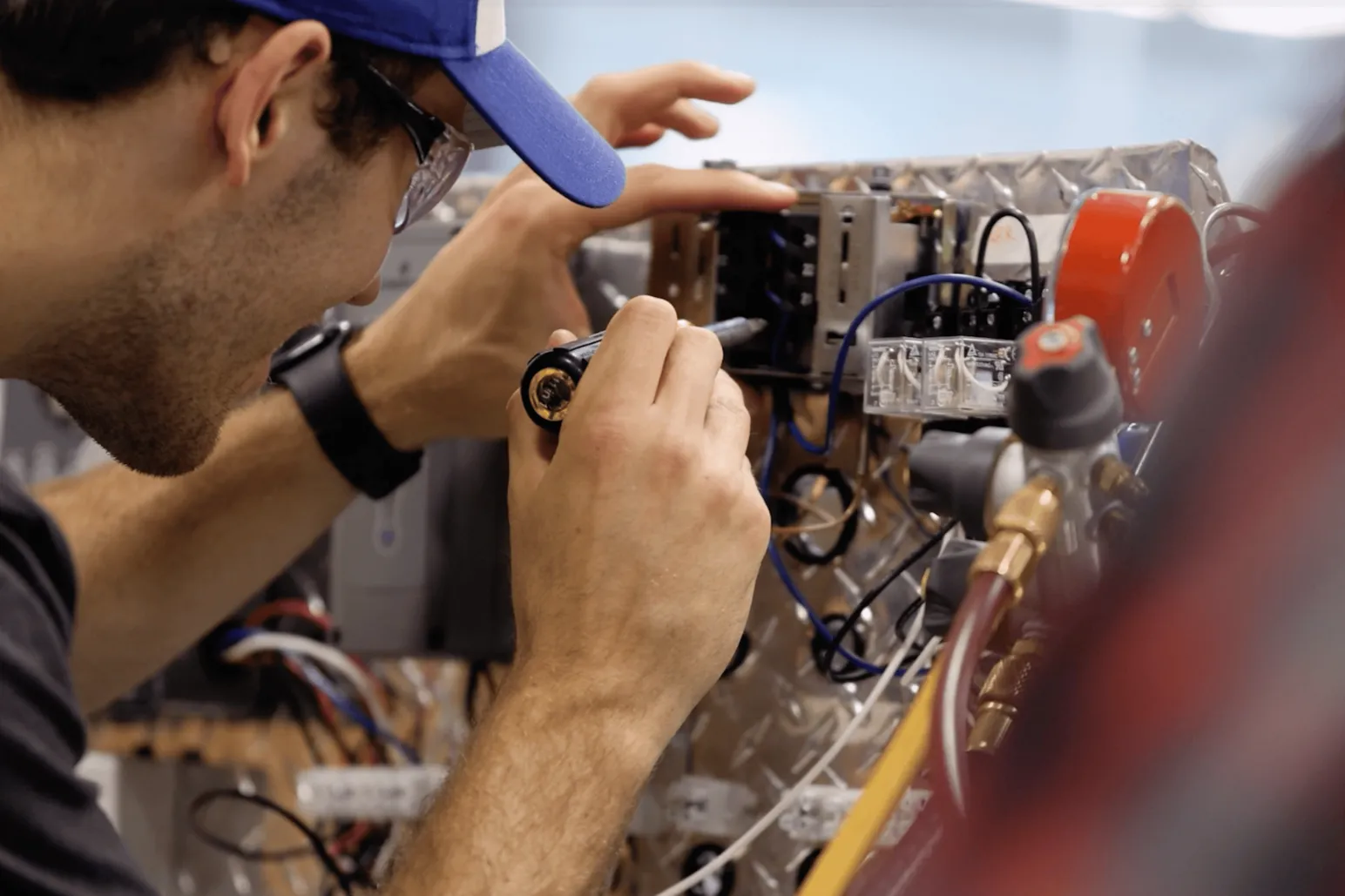Construction student performing detailed electrical wiring work at RRC Polytech technical training center