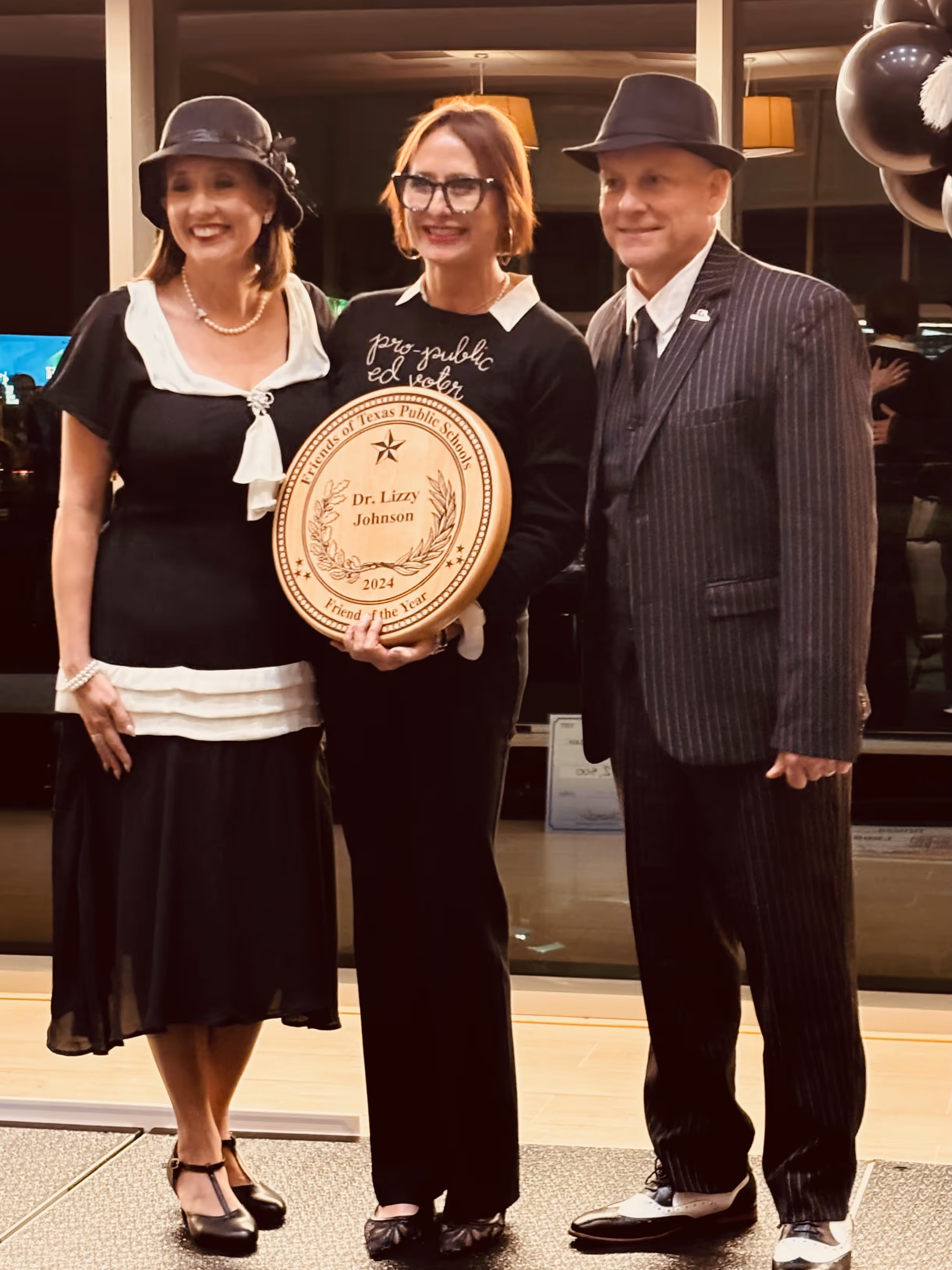 Two people taking a picture with Dr. Lizzy