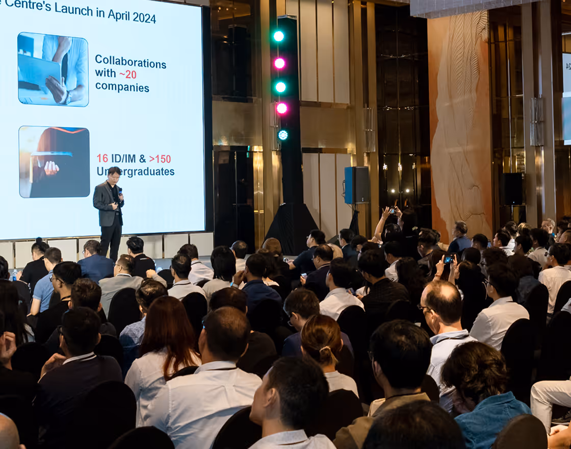 Group of people sitting around tables engaged in discussion during a meeting or conference.