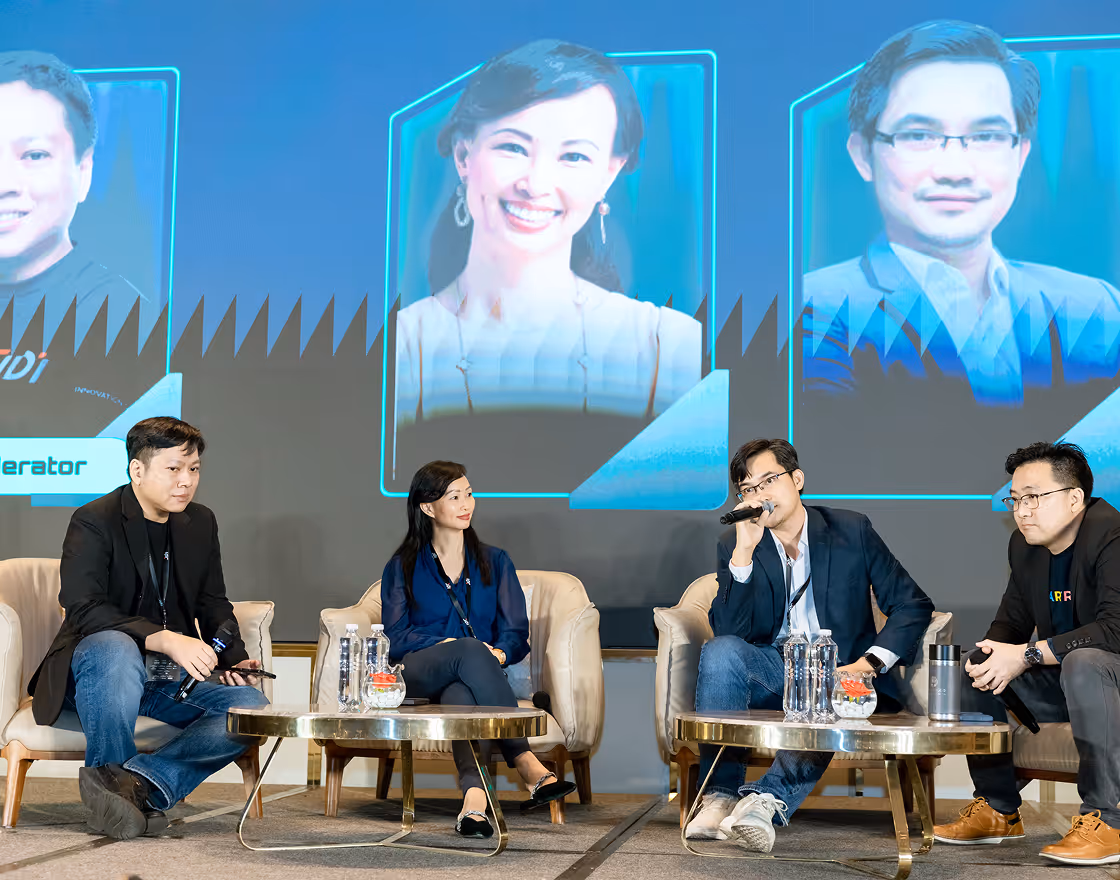 Audience of diverse people sitting and clapping at an indoor event or conference.