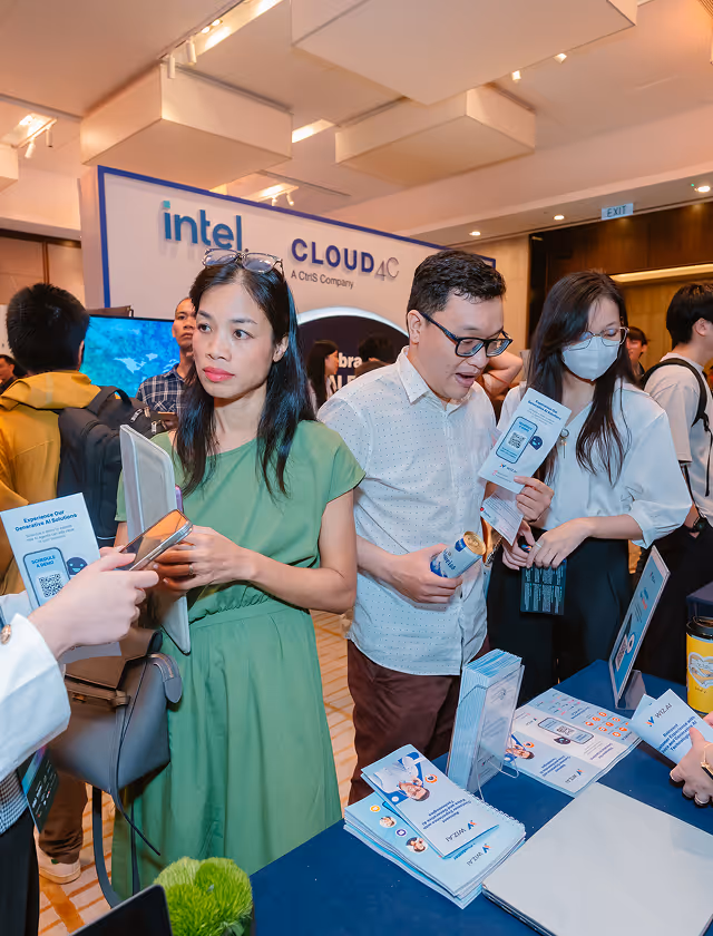 People interacting and looking at brochures at an Intel Cloud 4C event booth.