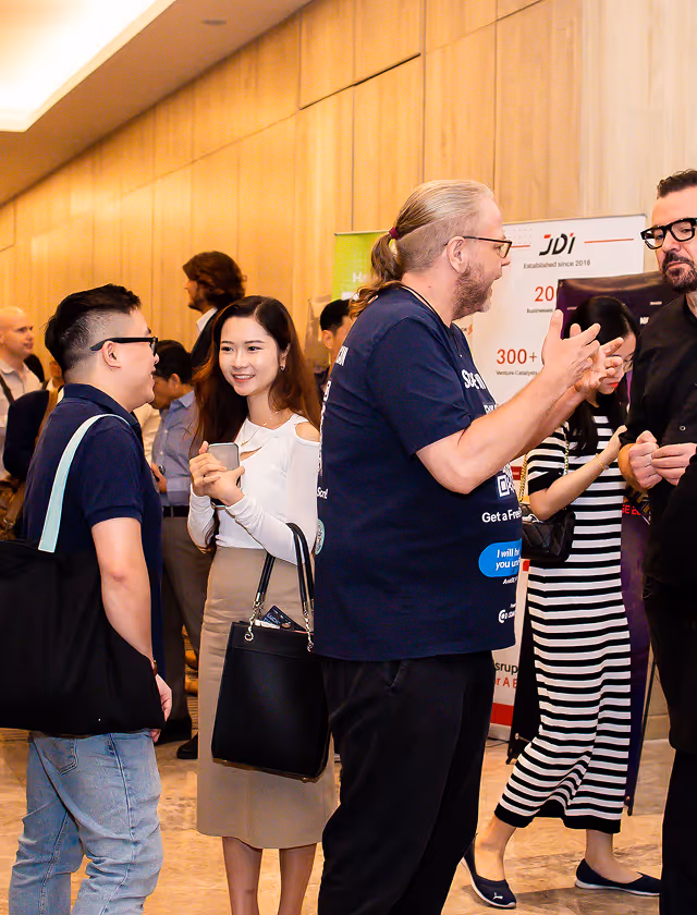 People engaging in conversation at an indoor professional networking event.