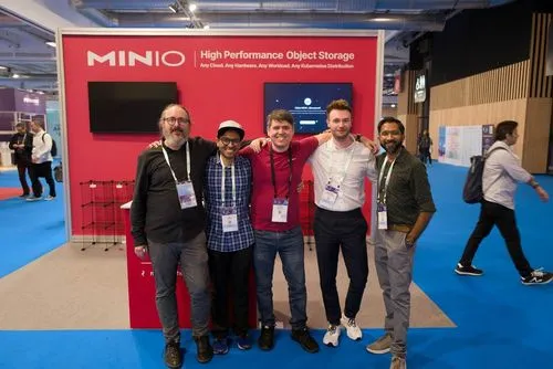 MinIO team posing at tech conference with High Performance Object Storage booth
