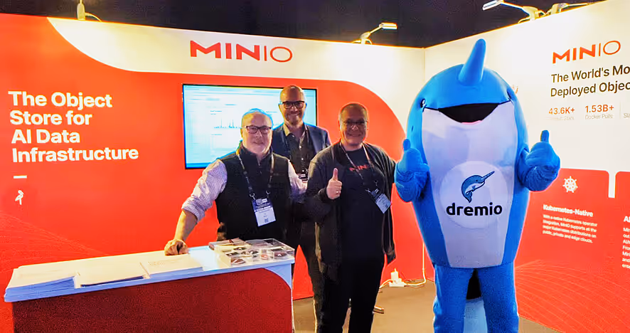 MinIO booth with team members and Dremio shark mascot at tech conference