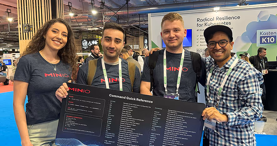 MINIO team posing with command quick reference poster at conference