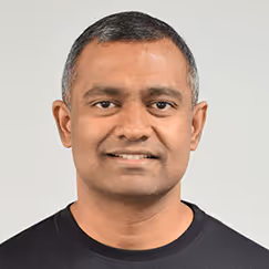 Smiling middle-aged man in black shirt against neutral background