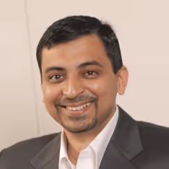 Professional headshot of a smiling person in a gray business suit