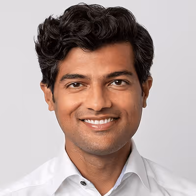 Smiling professional in white shirt with wavy dark hair
