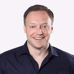 Smiling person in dark blue shirt against white background