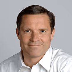 Professional headshot of a smiling person in a white button-up shirt