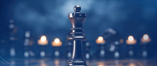 Chess queen piece standing tall among blurred candles in dramatic lighting