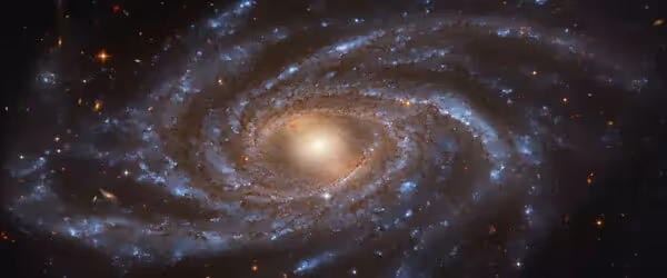 Spiral galaxy with bright center and swirling blue-white arms in space