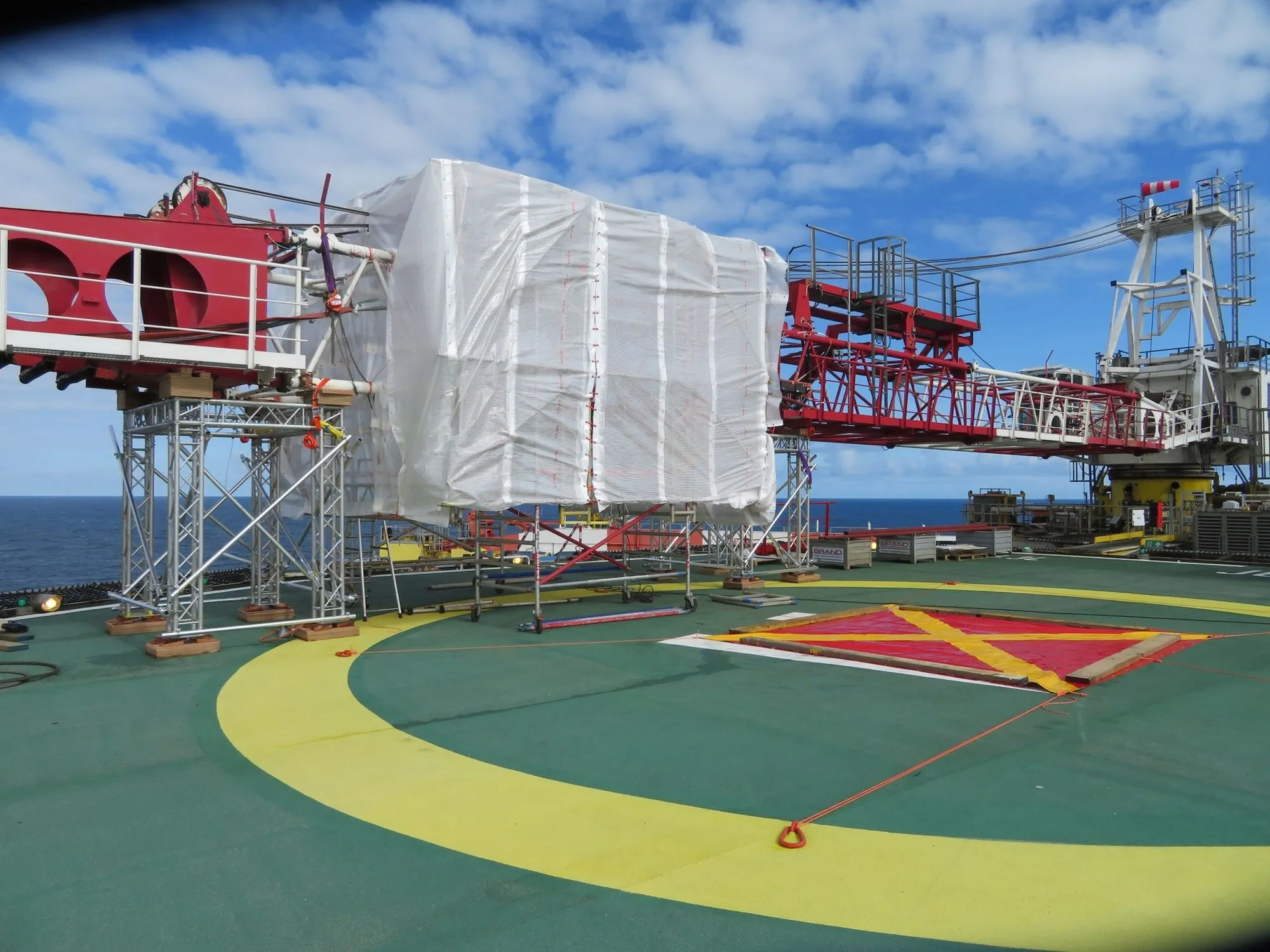 Repairing a crane boom with a temporary boom rest supporting the boom during welding activities offshore. 