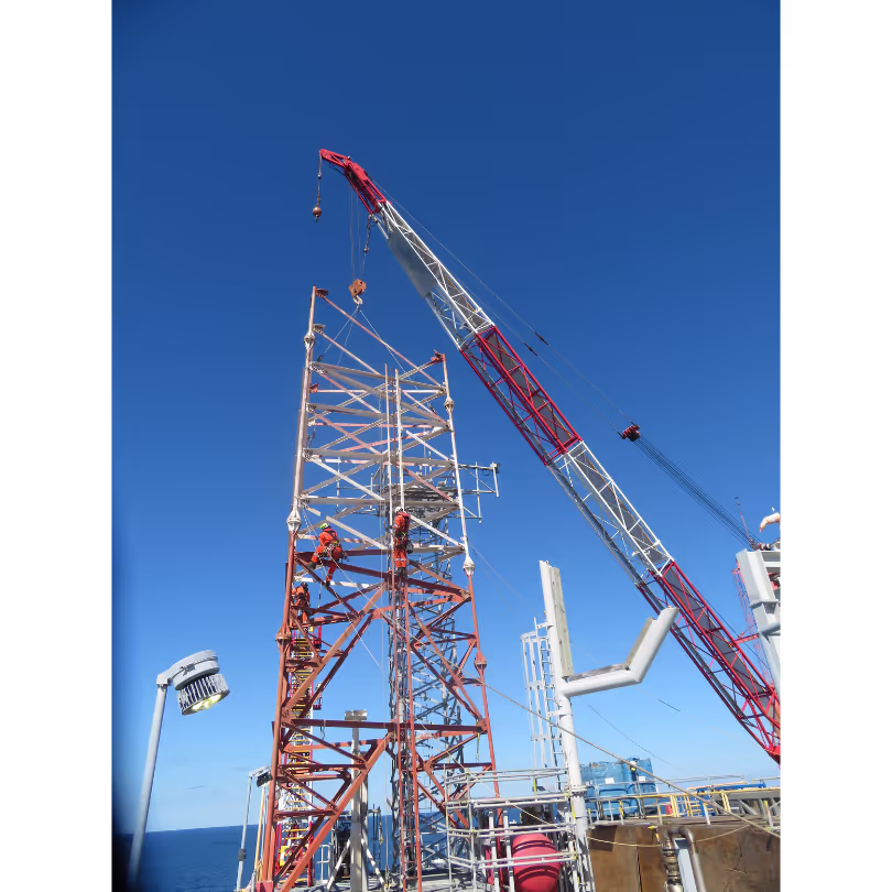 Bottom part of flare tower removed by deck crane, Conbit rope access technicians securely connecting components for efficient dismantling.
