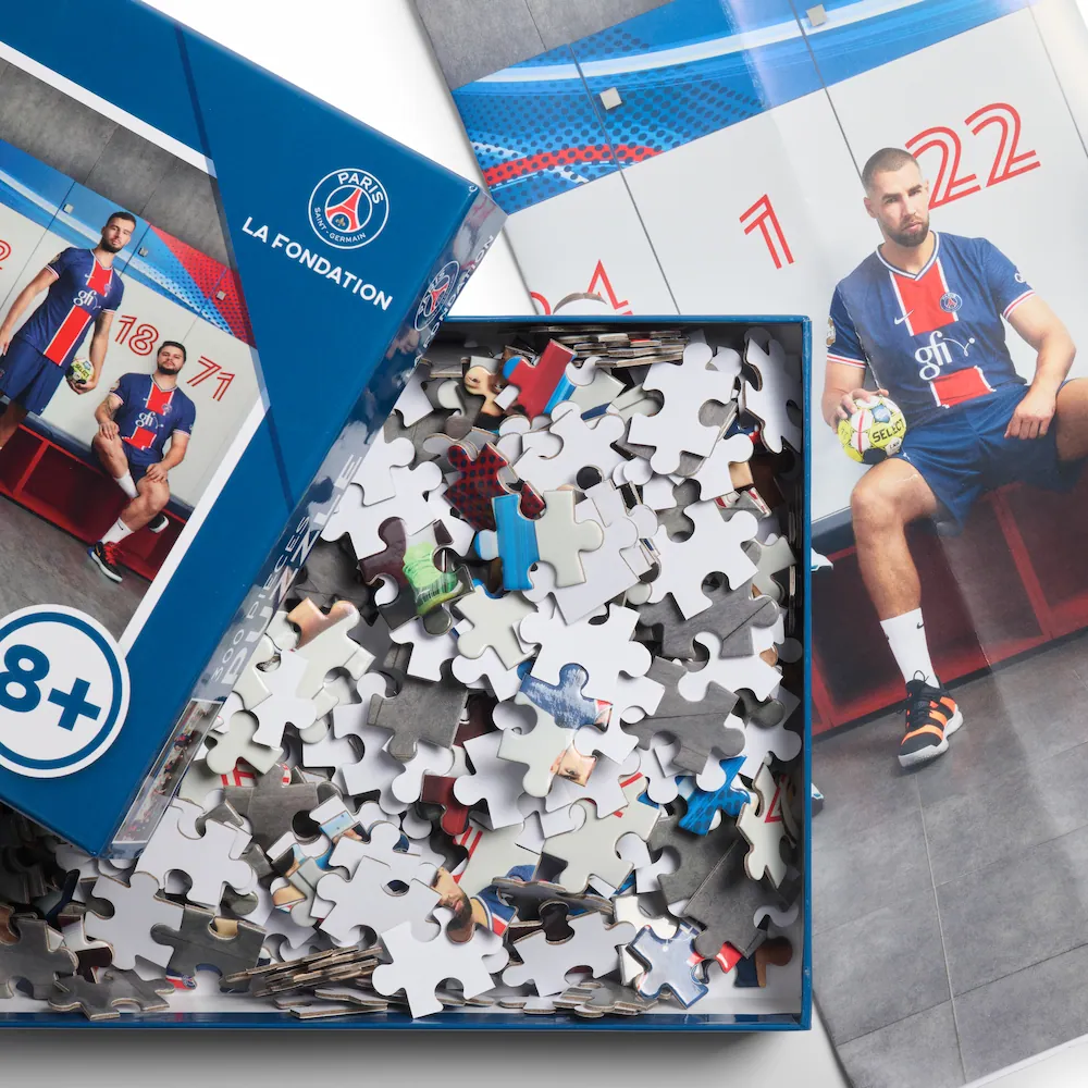 PSG La Fondation 300-Teile-Puzzle für Kinder ab 8 Jahren mit Paris Saint-Germain Handball-Spielern im Trikot – geöffnete Puzzle-Box mit Teilen