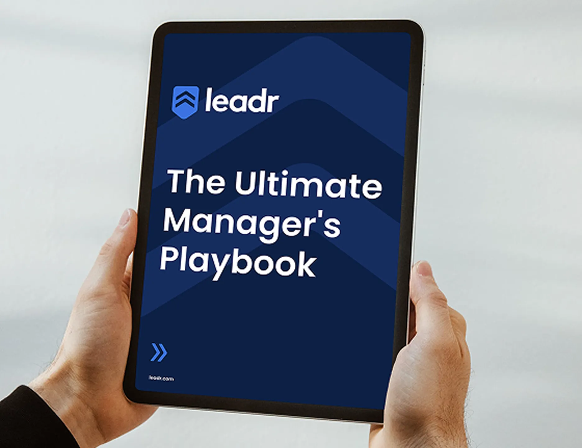 Tablet screen showing Leadr branding and "The Ultimate Manager's Playbook" title.