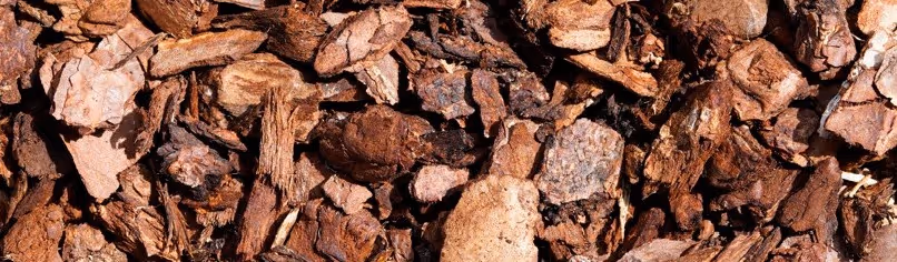 Brown wood bark chips and mulch for landscaping material hauling and garden supply transportation services