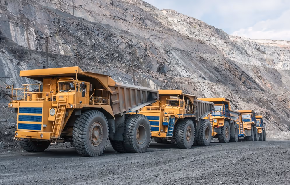 Fleet of dump trucks at commercial quarry providing excavation support and hauling services
