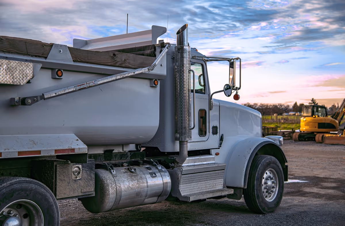 White dump truck at sunset ready for recycling material transport and hauling services
