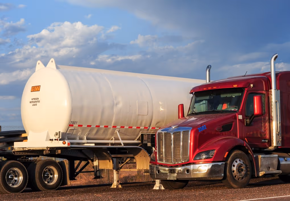 Red truck with white nitrogen refrigerated liquid tanker for cryogenic transport services