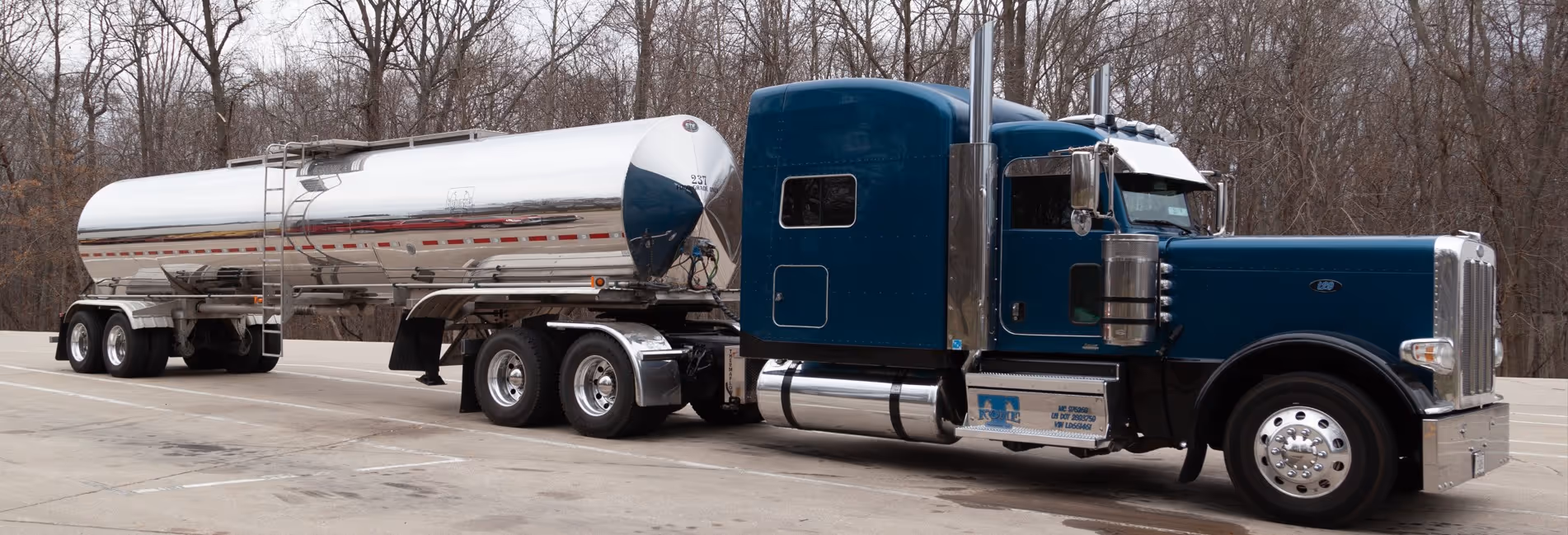 Blue semi truck with polished aluminum tanker trailer for commercial food-based liquid transport