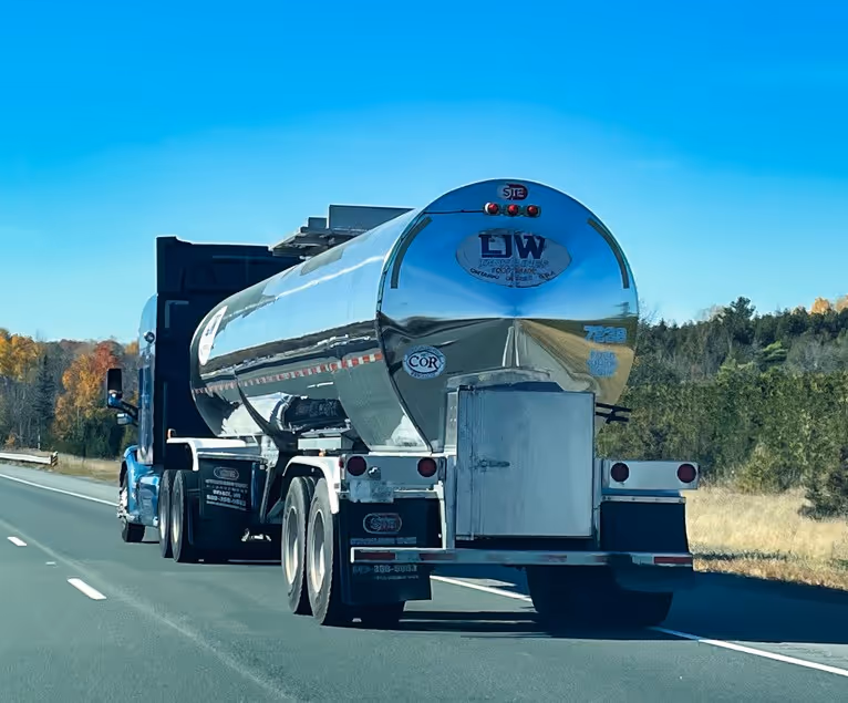 Polished chrome tanker truck on highway for commercial bulk liquid transport services
