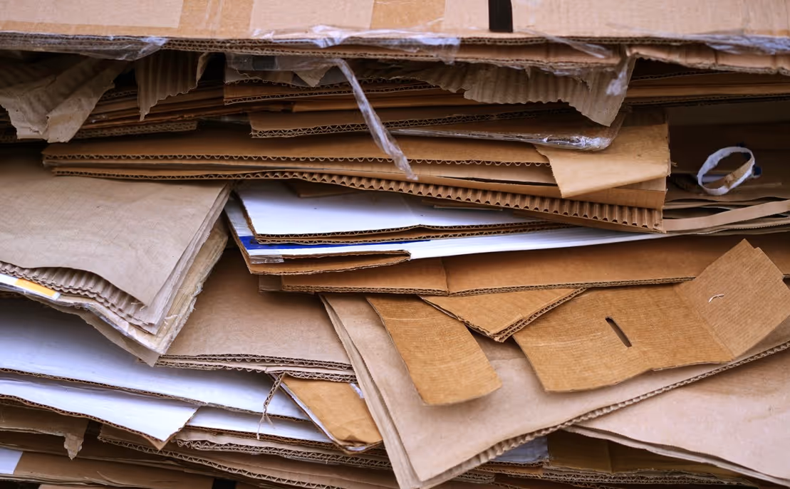 Flattened corrugated cardboard waste for commercial recycling and bulk hauling services