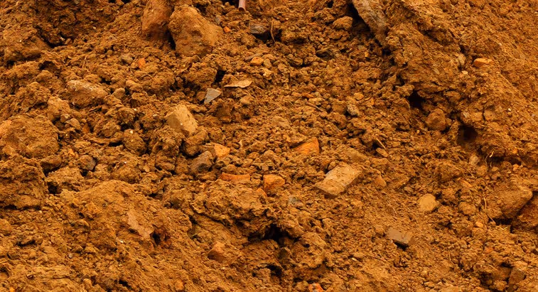 Clay and excavated soil spoils from foundation digging requiring excavation support and soil disposal